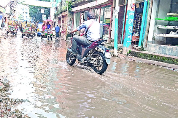 সড়কে ড্রেনের পানি ১২ মাস বৃষ্টি হলেই কোমরপানি ভাঙাচোরা সড়কে চলা দায়